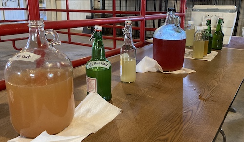 Various meads line a table, ready for tasting